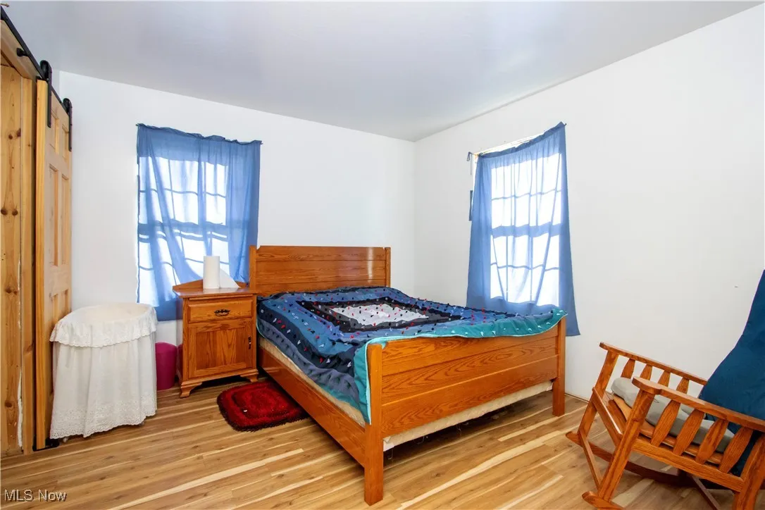Bedroom featuring a barn door and light wood finished floors