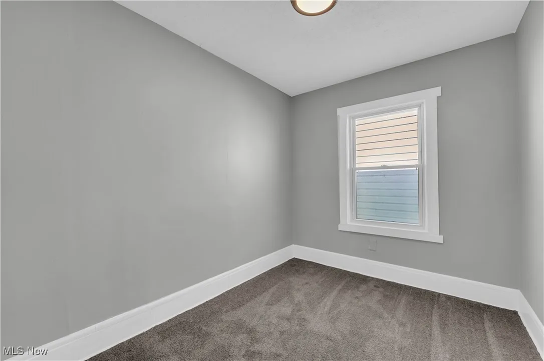 Empty room featuring carpet and baseboards