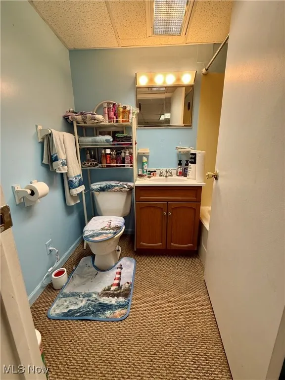 Full bath featuring light colored carpet, vanity, shower / tub combination, and a drop ceiling