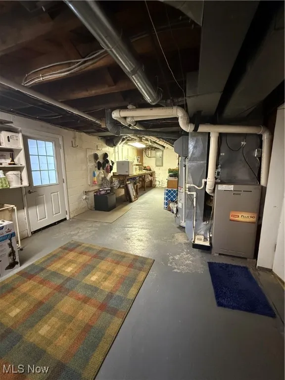 Below grade area with heating unit and electric panel