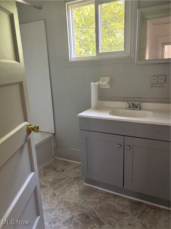 Bathroom featuring vanity, backsplash, and shower / bath combination