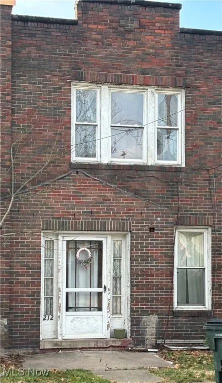 Entrance to property featuring brick siding and a patio