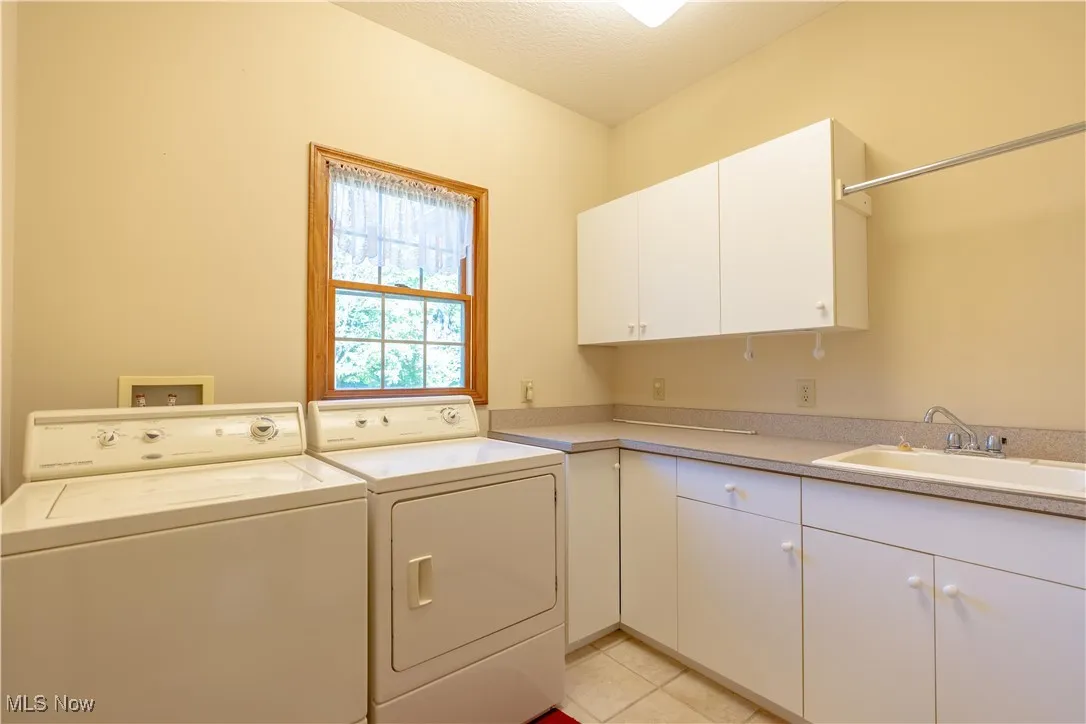 Main floor laundry with washer and dryer and cabinet space