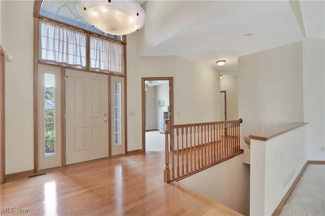 Foyer entrance featuring light wood-style floors and a high ceiling