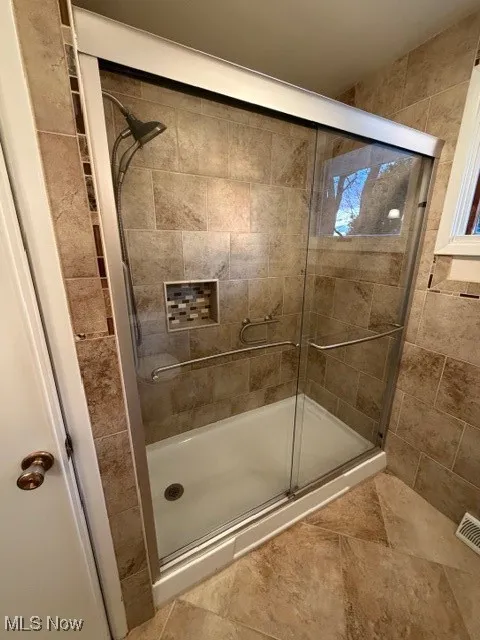 Full bathroom featuring a shower stall