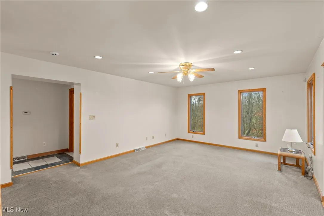 Empty room featuring recessed lighting, light colored carpet, and ceiling fan