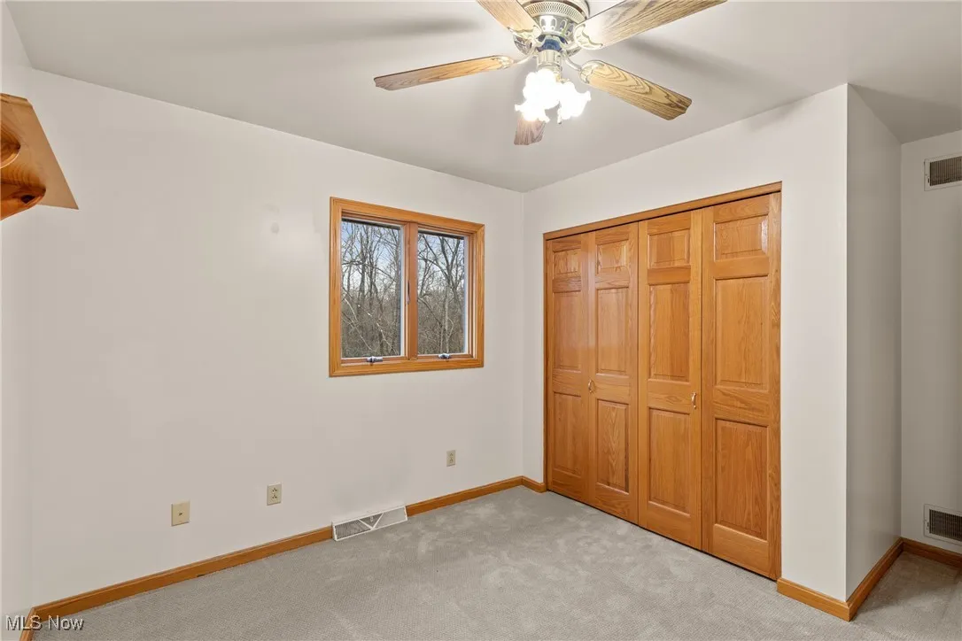 Unfurnished bedroom featuring carpet, a ceiling fan, and a closet
