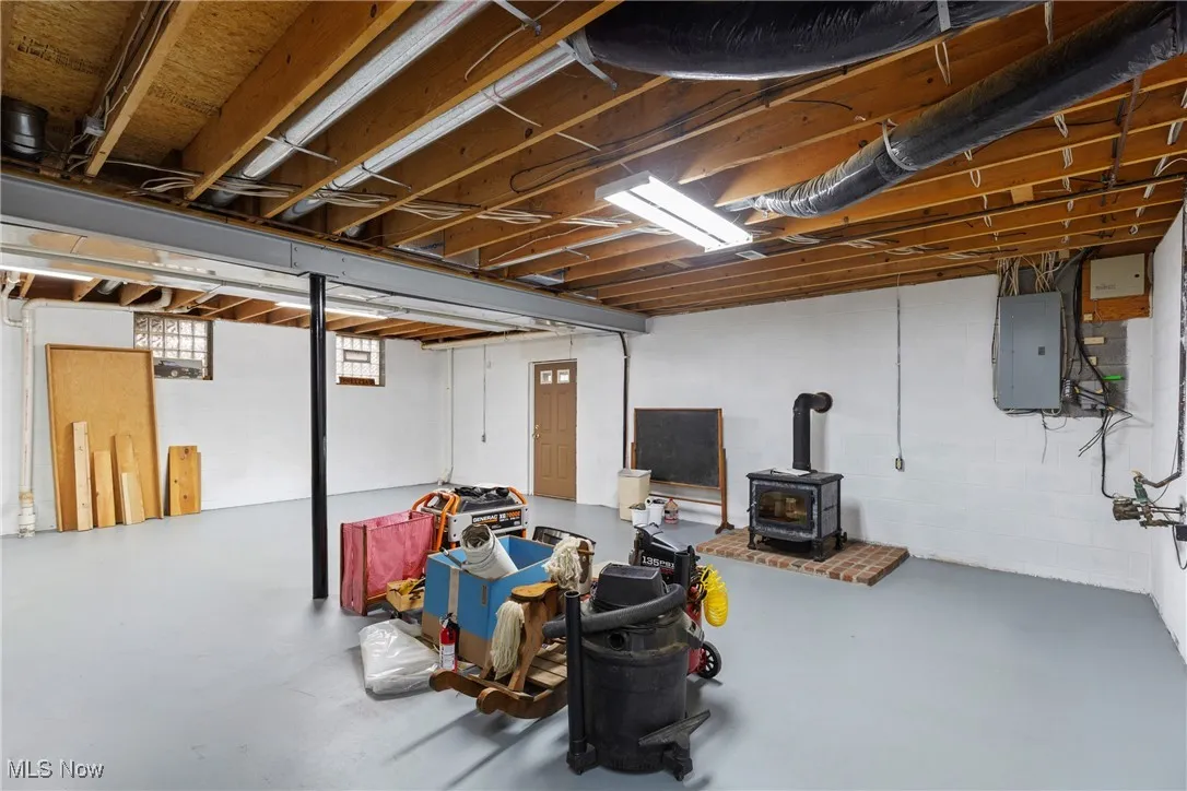 Basement with a wood stove and electric panel