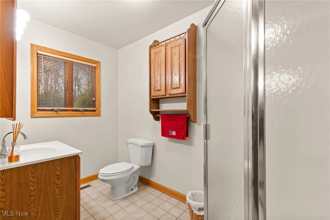 Full bathroom with light tile patterned floors, vanity, and a stall shower
