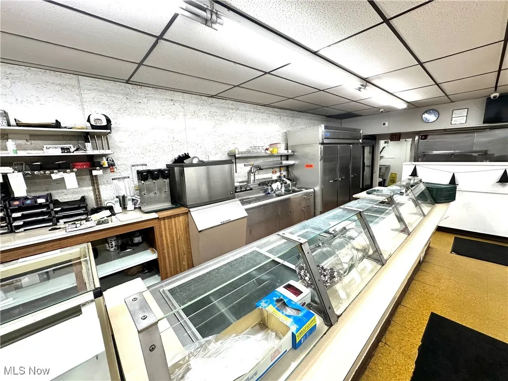 Kitchen featuring a drop ceiling and open shelves