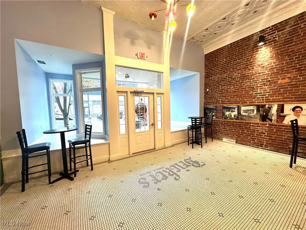 Welcome area featuring brick wall and a towering ceiling