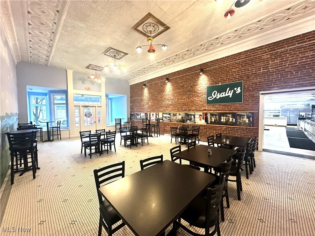 Carpeted dining room featuring brick wall and plenty of natural light
