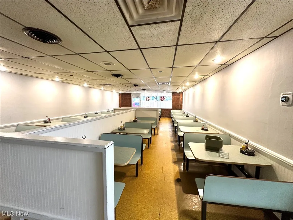 Dining area featuring a paneled ceiling and dark floors