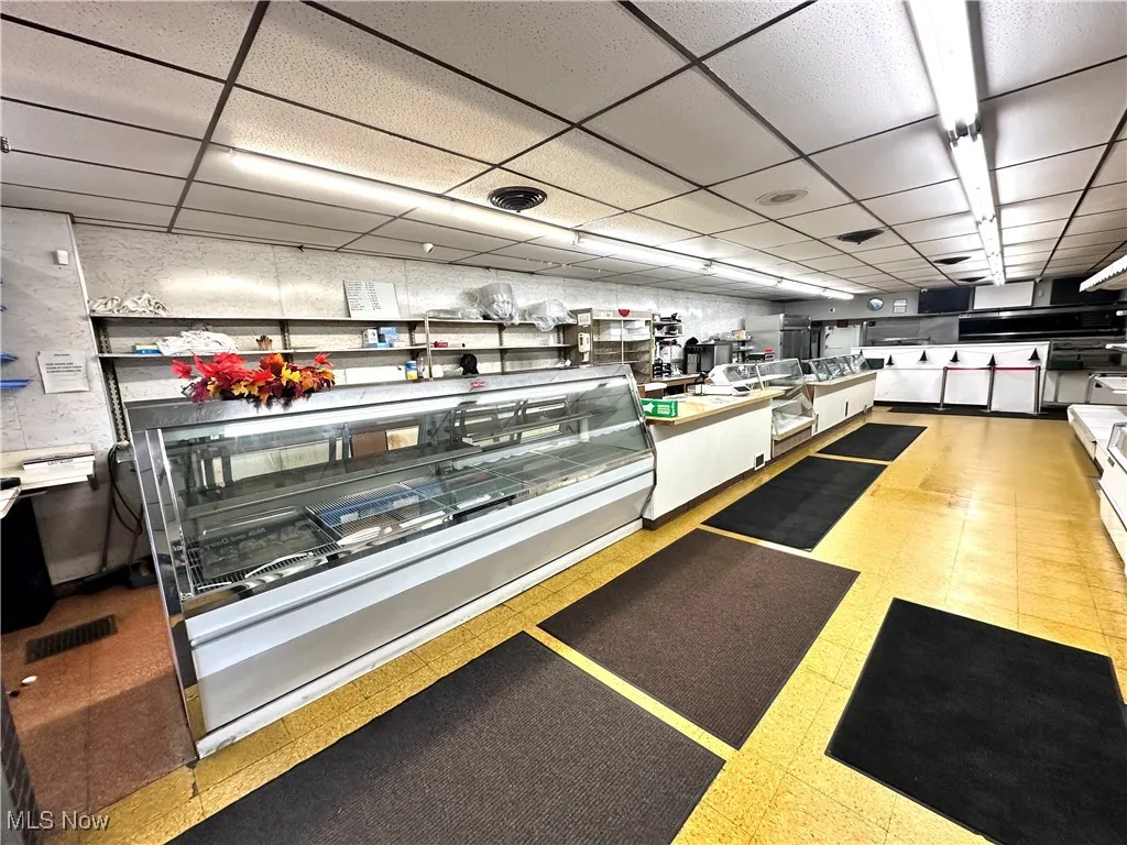 Kitchen with a paneled ceiling and white cabinetry