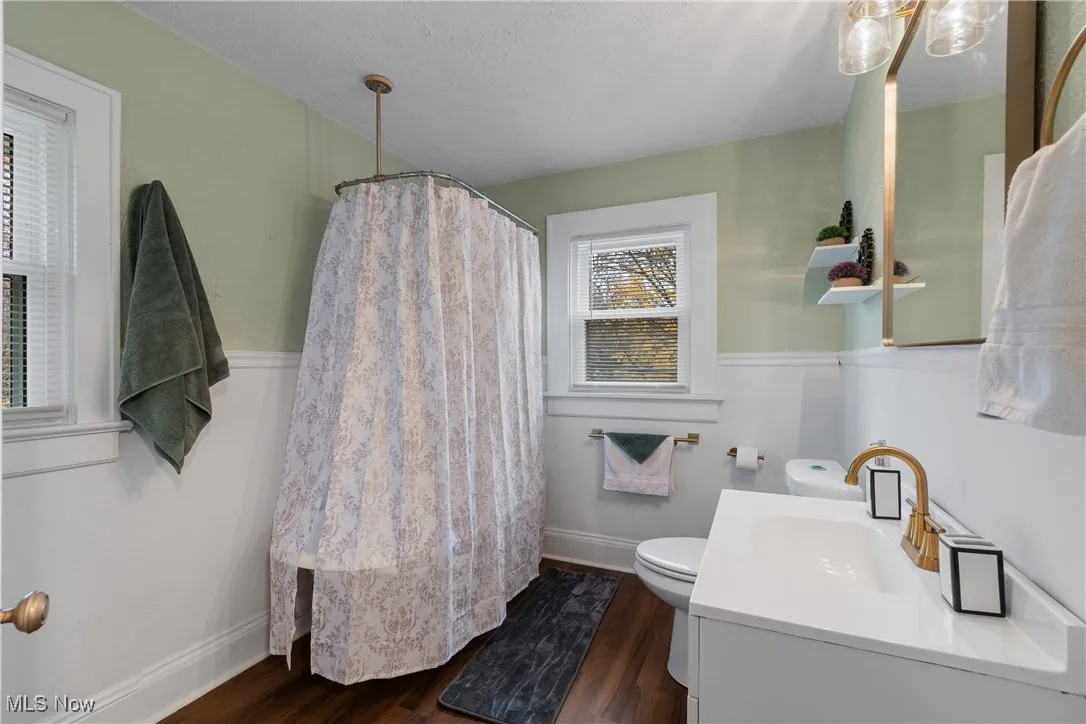 Full bathroom with a shower with curtain, dark wood finished floors, and vanity
