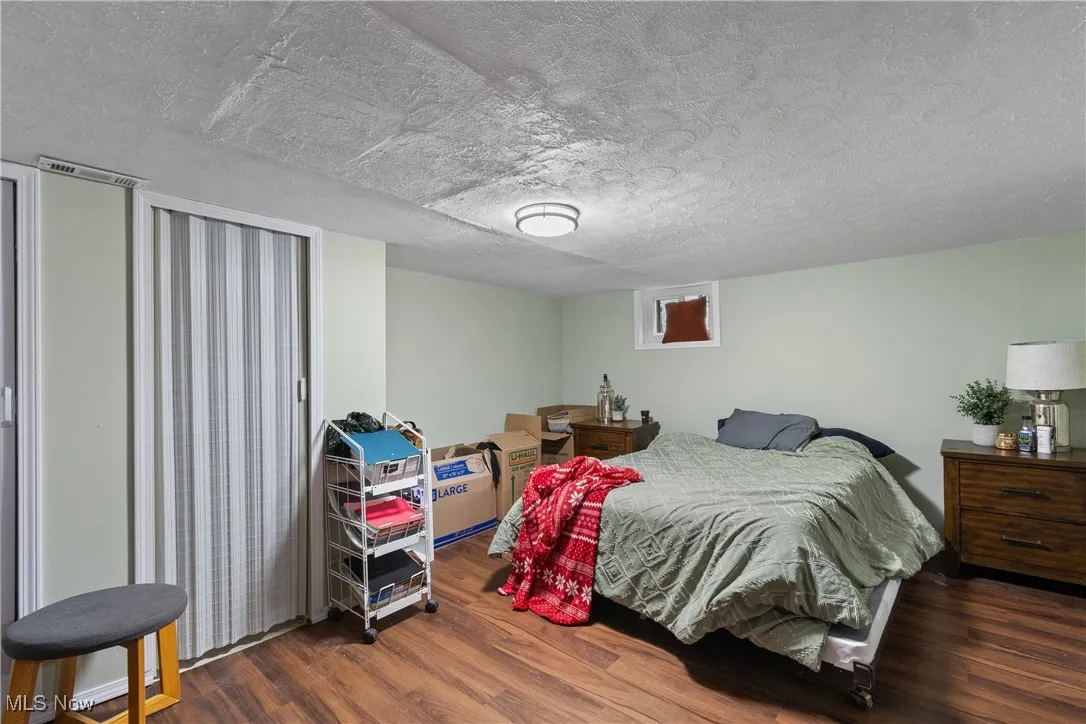 Bedroom featuring a textured ceiling and dark wood finished floors