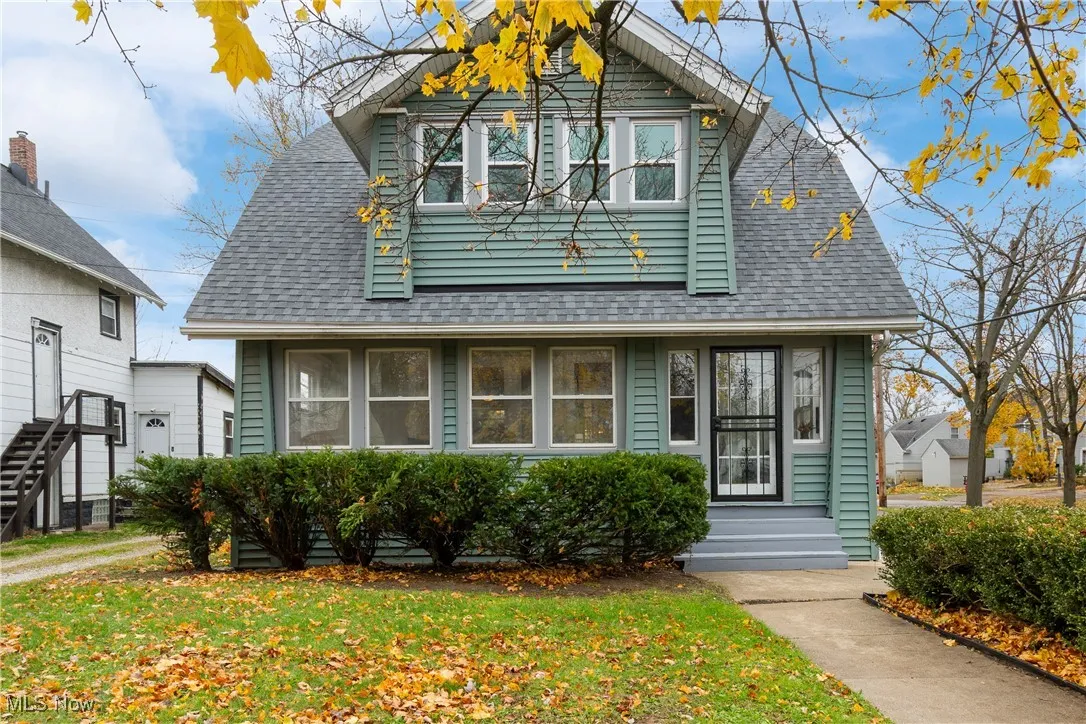 View of front facade with roof with shingles and a front lawn