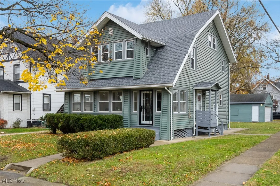 View of front facade with roof with shingles and a front yard