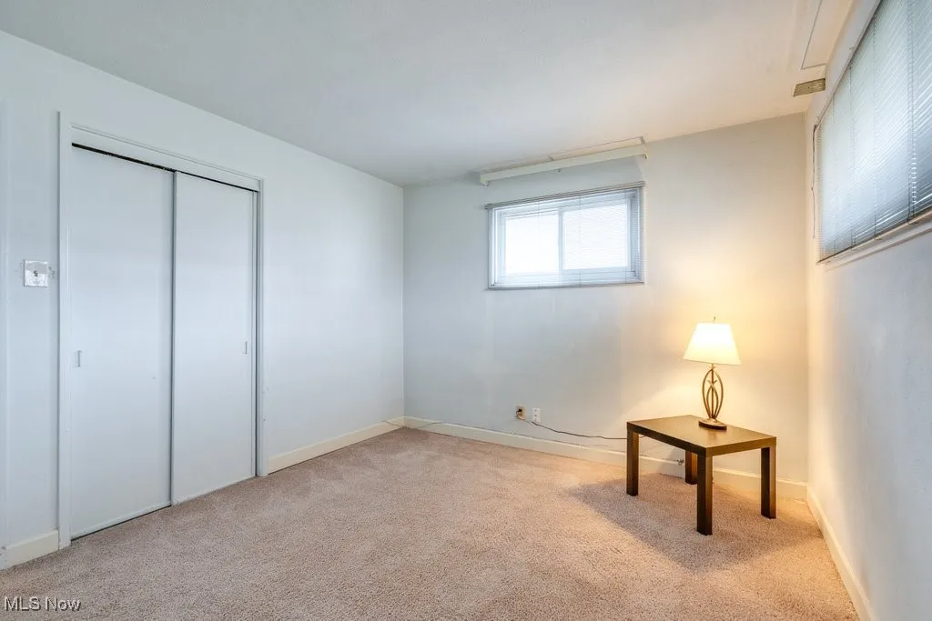 Unfurnished bedroom featuring light carpet and a closet