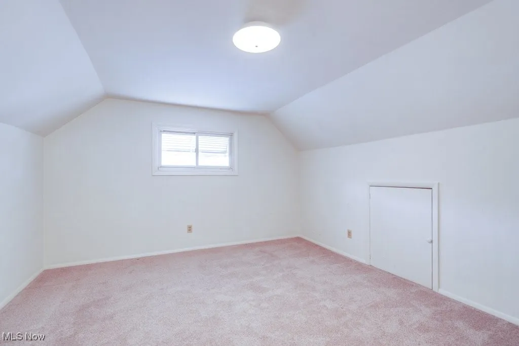 Bonus room featuring vaulted ceiling and carpet flooring