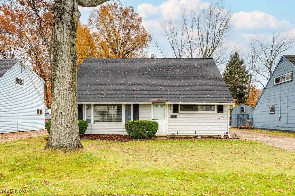 New england style home featuring a front lawn and roof with shingles