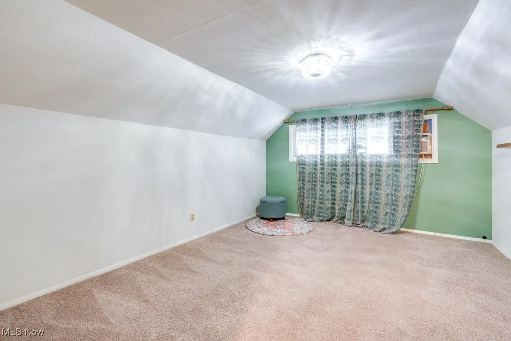 Bonus room featuring lofted ceiling and carpet flooring
