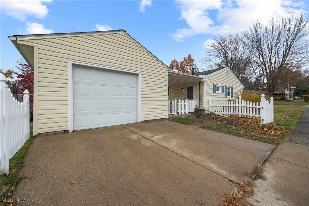 View of front of house with concrete driveway, a garage, and covered porch