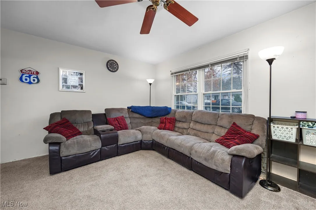 Living room with carpet and a ceiling fan
