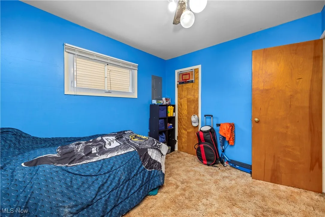 Bedroom featuring carpet flooring, electric panel, and a ceiling fan