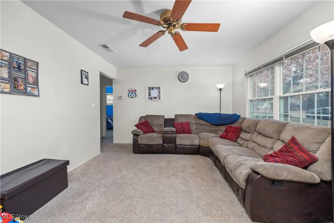 Living room with light carpet and ceiling fan