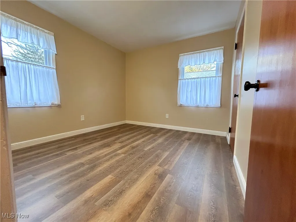 Unfurnished room featuring wood finished floors and baseboards