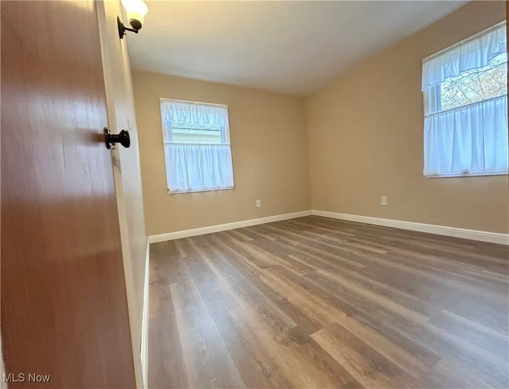 Unfurnished room with plenty of natural light and wood finished floors