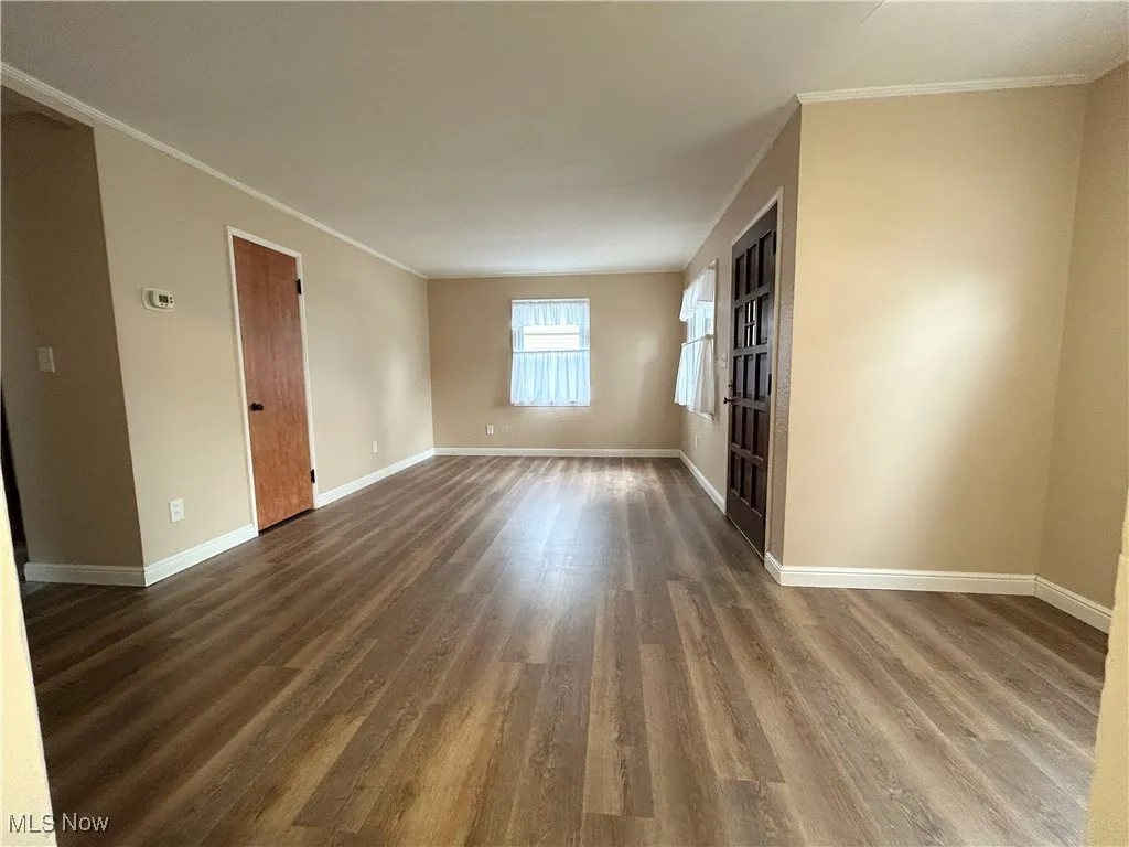 Unfurnished room featuring ornamental molding and wood finished floors