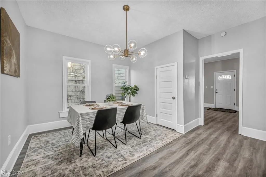 Dining area featuring a textured ceiling, light wood-type flooring, and a chandelier