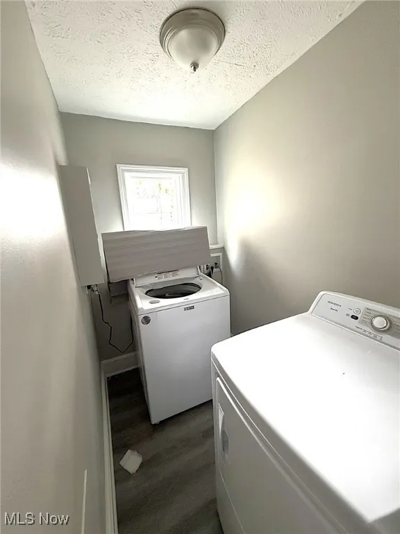added 1st Floor Laundry area featuring dark wood-type flooring, a textured ceiling, and washing machine and clothes dryer