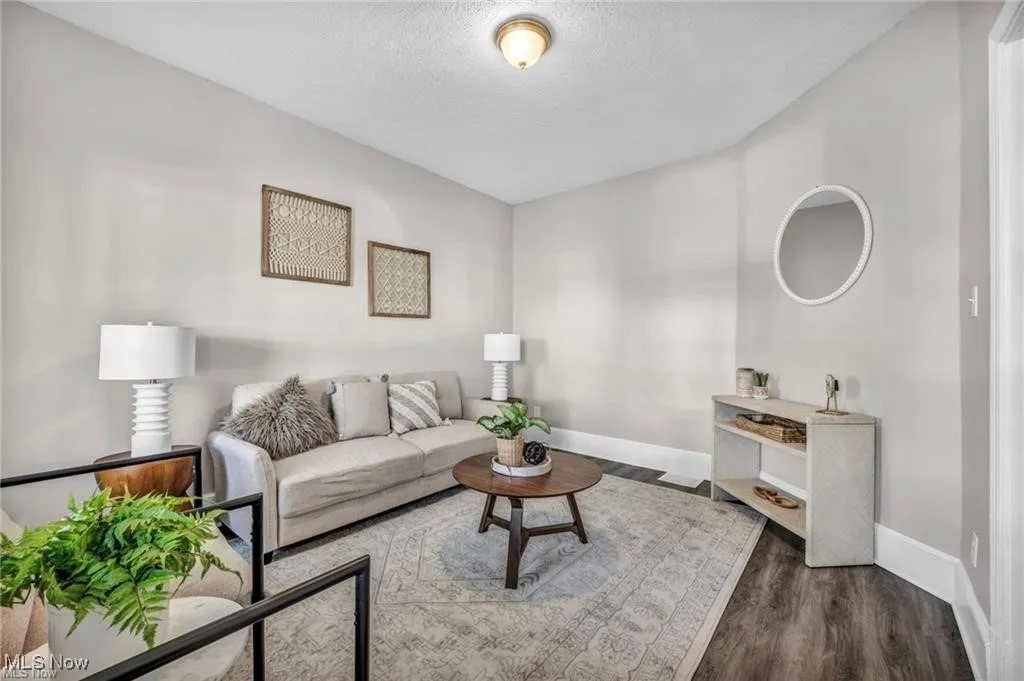Living area featuring dark wood finished floors and a textured ceiling