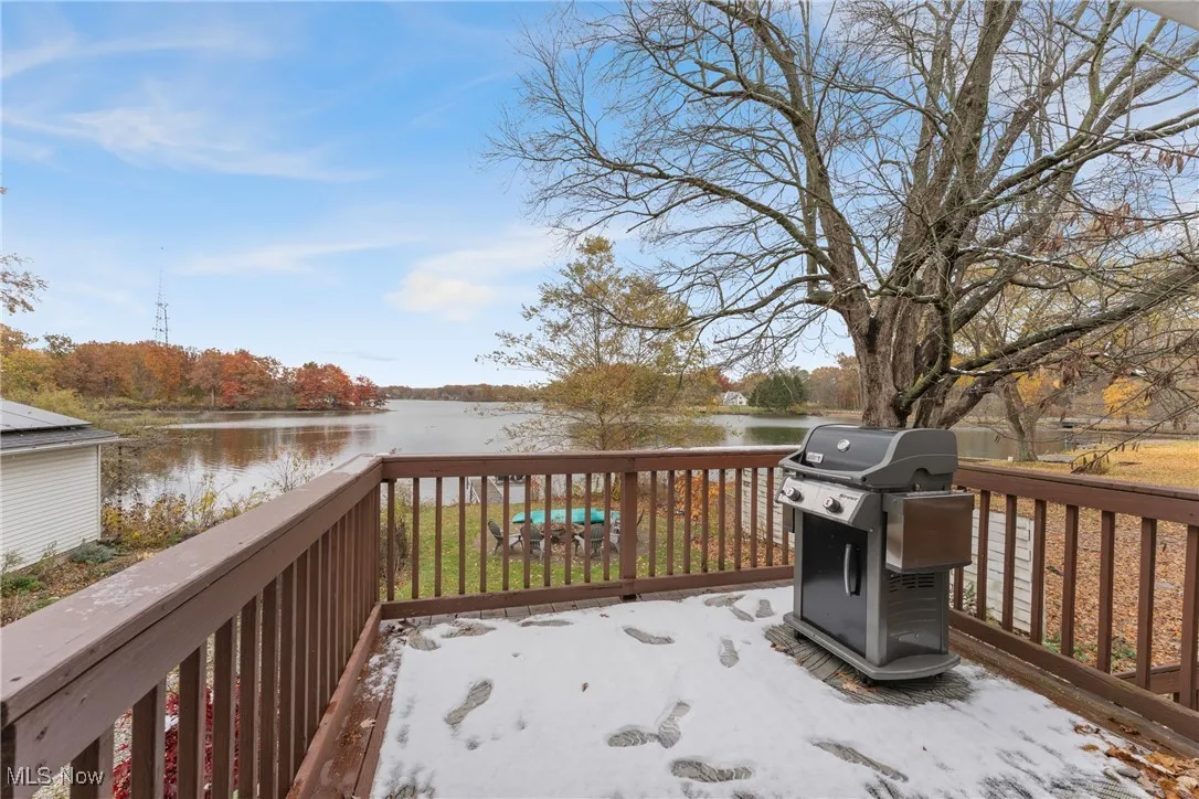 Wooden terrace featuring a water view and grilling area
