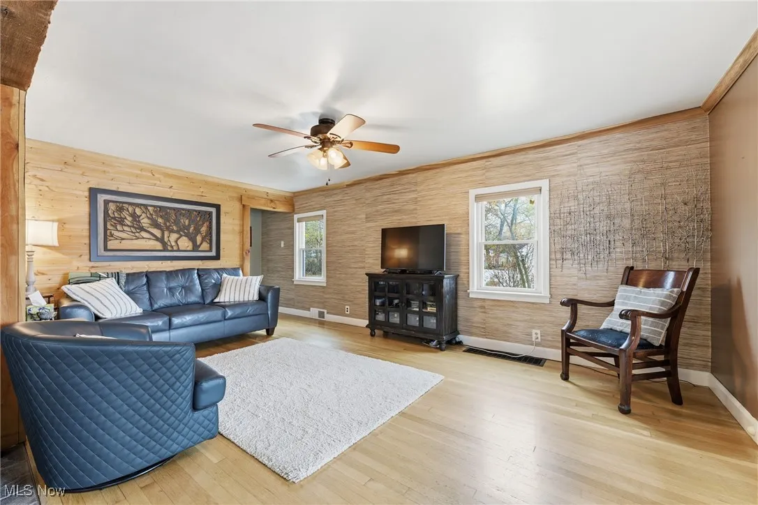 Living area with light wood-type flooring, plenty of natural light, and ceiling fan