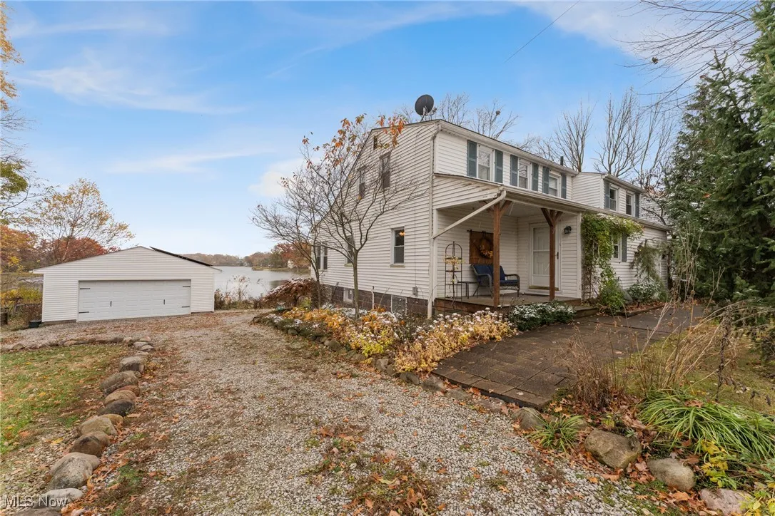 View of home's exterior featuring a garage, an outbuilding, and covered porch