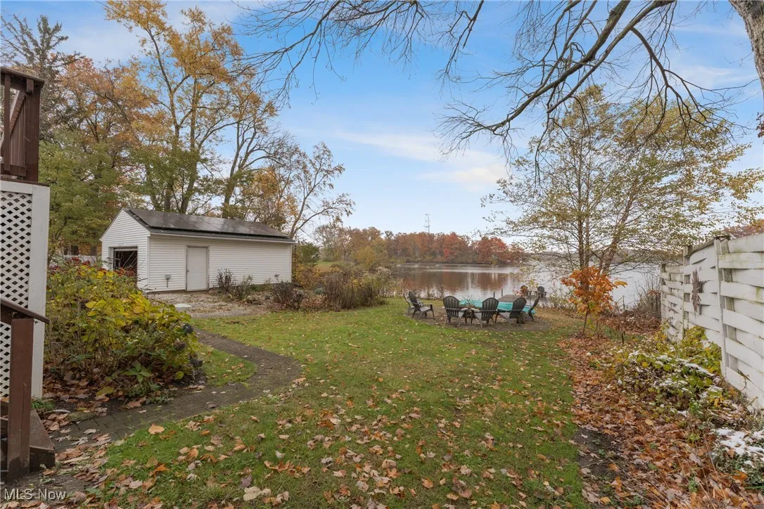 View of grassy yard with a water view and an outdoor structure