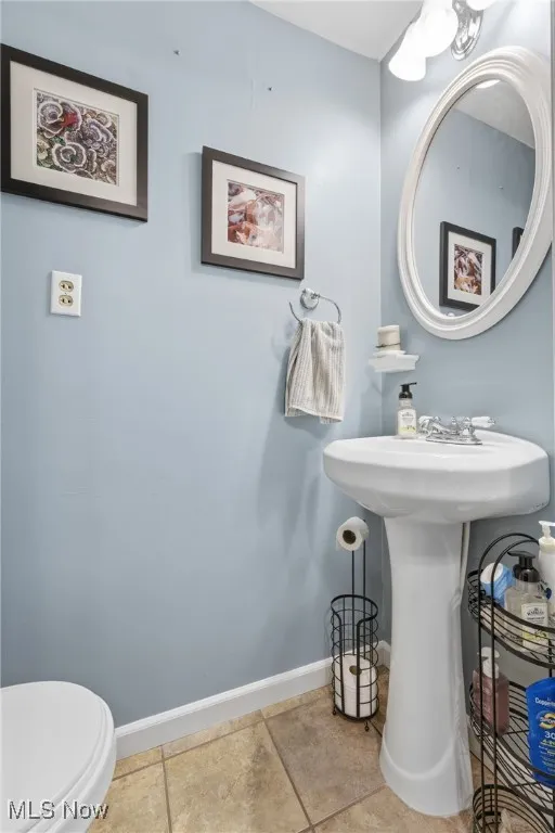 Half bath featuring baseboards and tile patterned floors