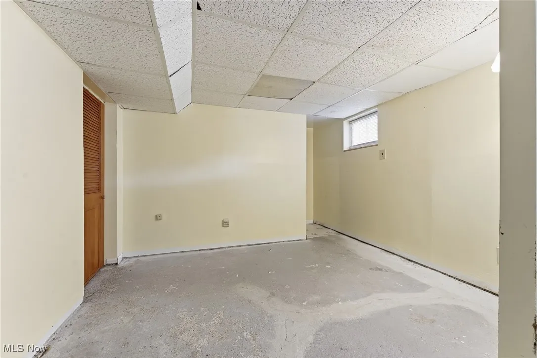 Basement with a drop ceiling and baseboards