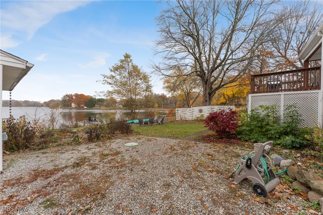 View of yard with a deck with water view