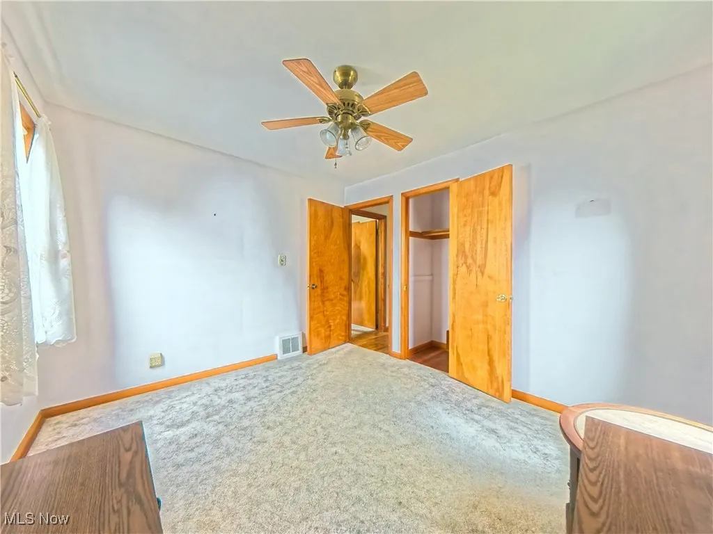 Unfurnished bedroom with a ceiling fan, carpet, and a closet