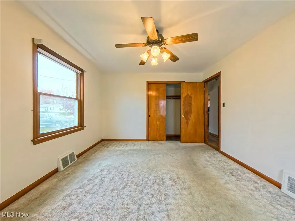 Unfurnished bedroom with a closet, carpet flooring, and ceiling fan