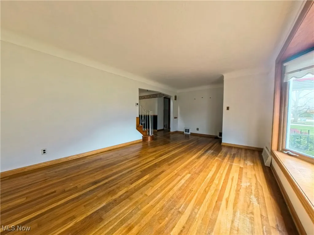 Unfurnished room with light wood-style flooring and stairway