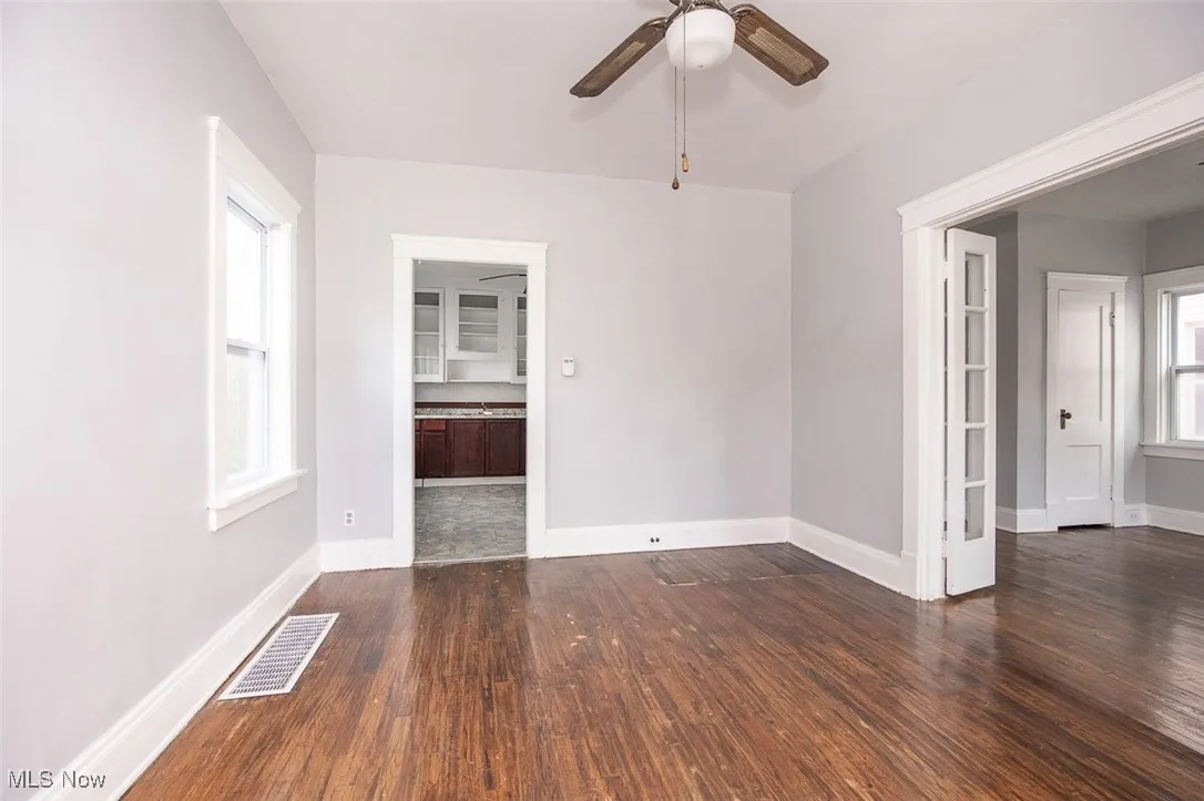 Spare room featuring dark wood-style flooring and ceiling fan