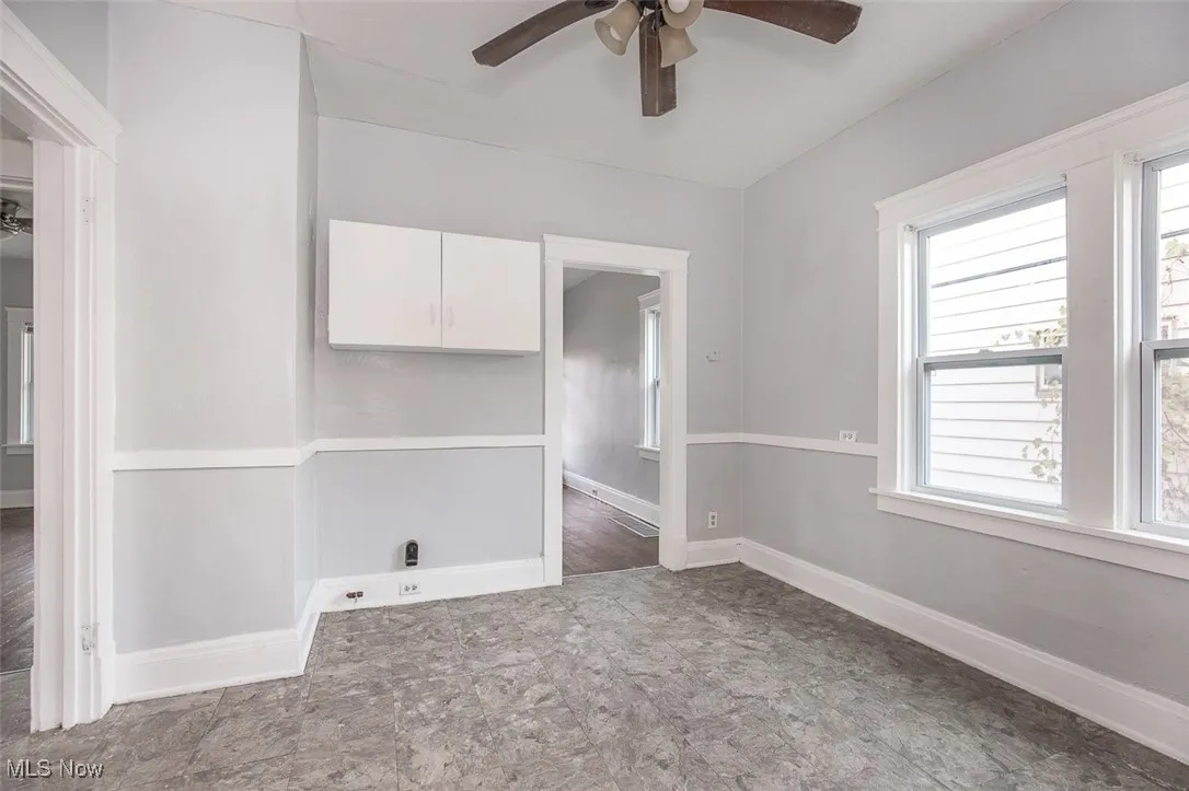 Empty room featuring ceiling fan and baseboards