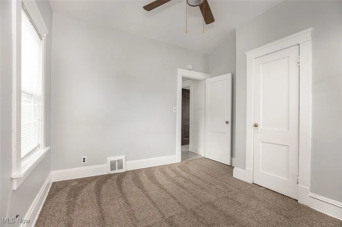 Unfurnished bedroom with carpet and a ceiling fan