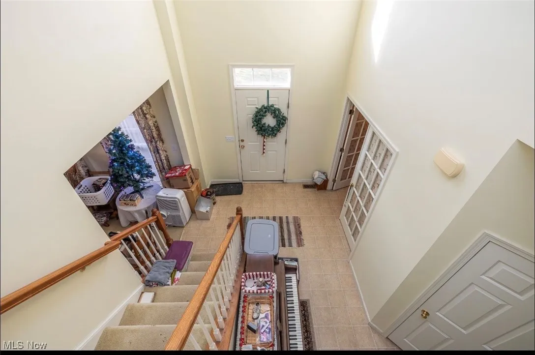 Entrance foyer featuring a towering ceiling and light tile patterned floors